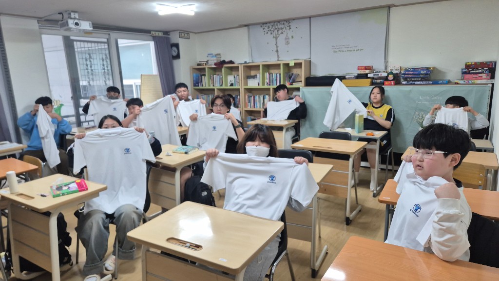 Students at a partner school holding donated Green Loop t-shirts